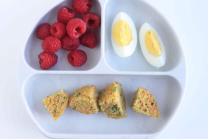 veggie muffins on white divided plate with berries and egg