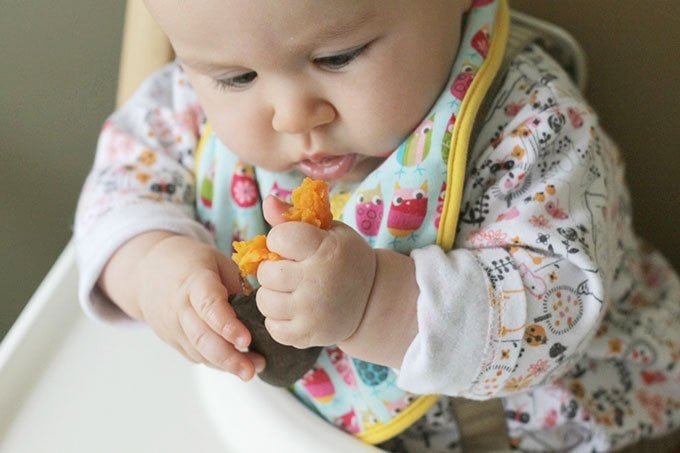 baby eating sweet potato wedge blw
