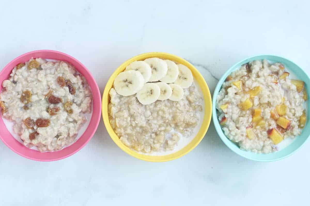 oatmeal with fruit in three kid bowls
