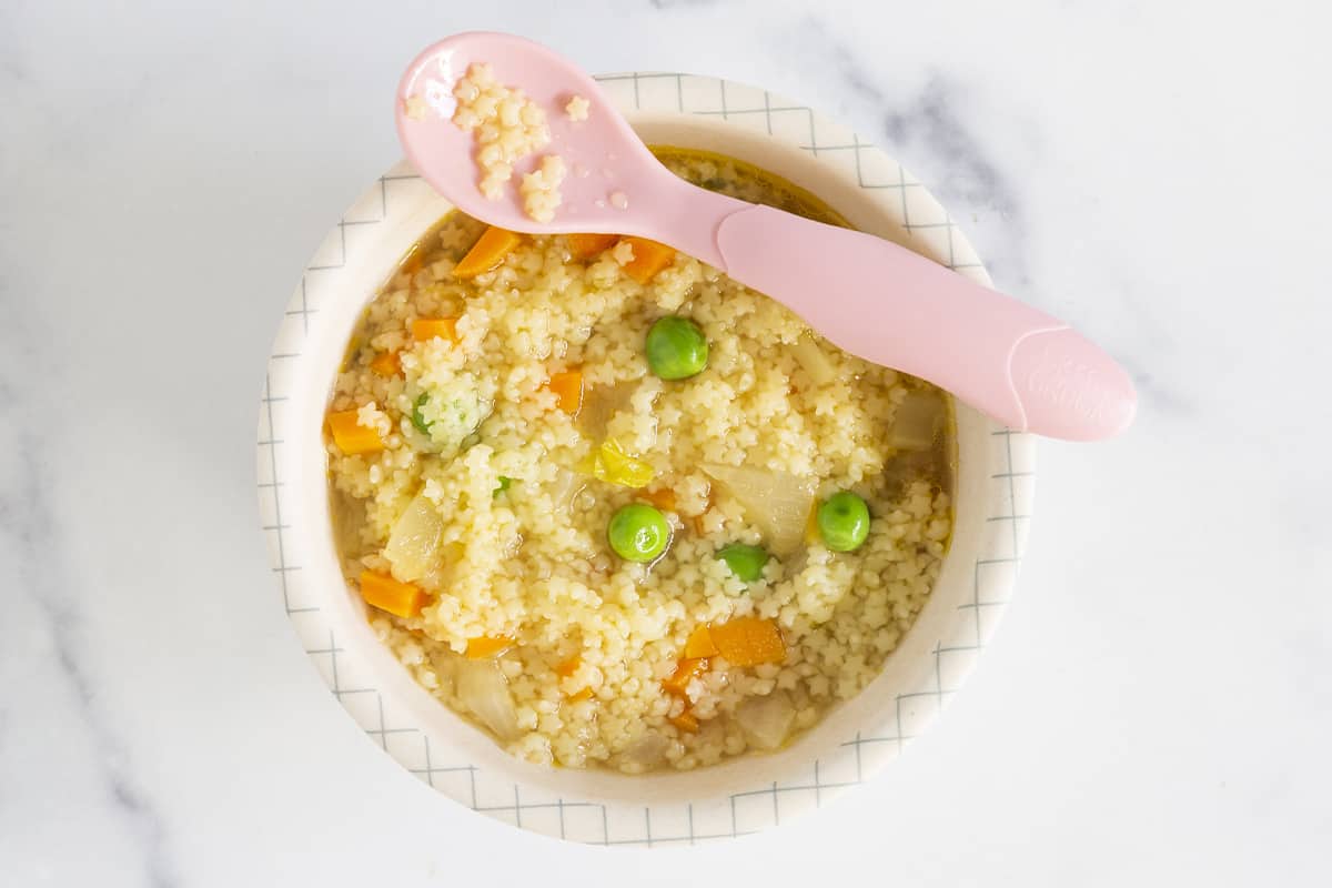 Pastina soup in kids bowl with spoon.