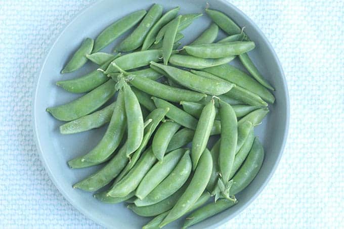raw-snap-peas-on-blue-plate