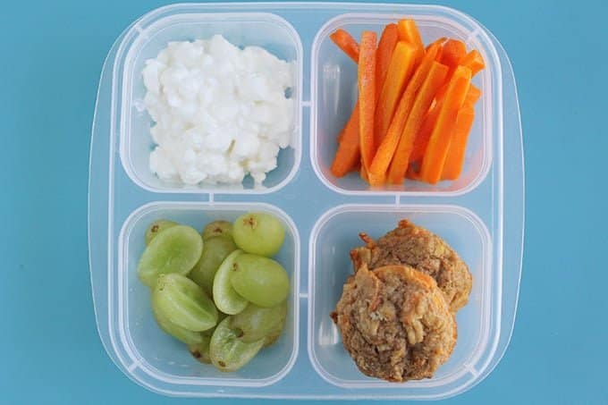 lunchbox with roasted carrots, muffins, cottage cheese, and grapes